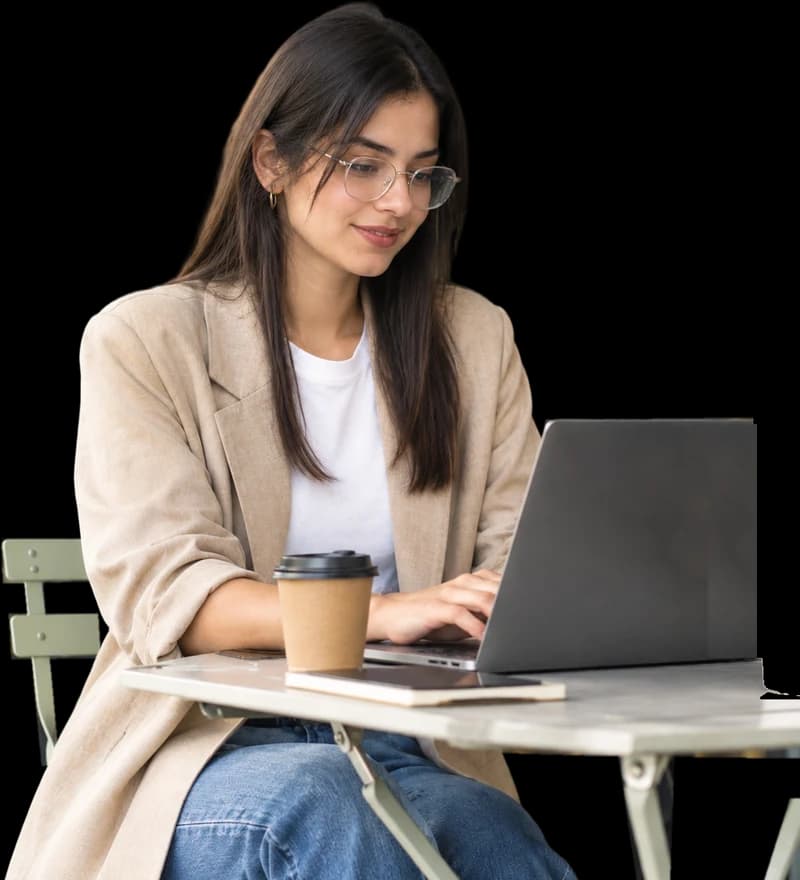 A shop owner setting up her online store on a laptop at a café table.